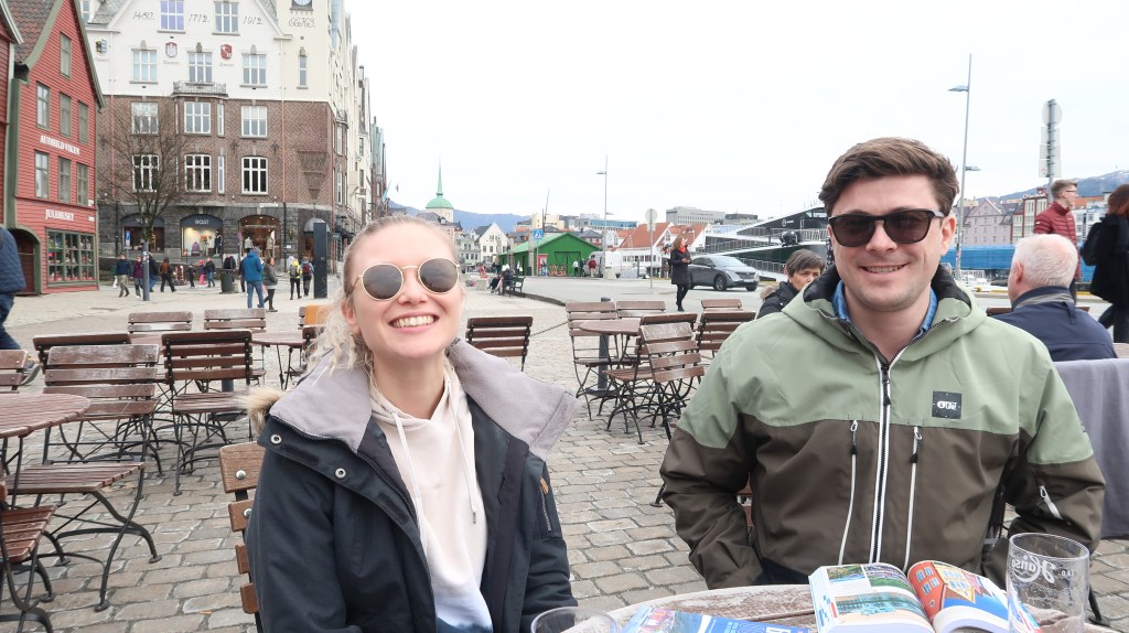 Man and woman sat outside in Bergen marina